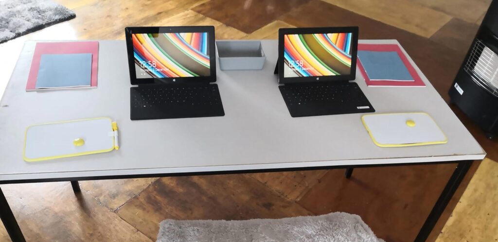 Ein zum Lernen gedeckter Tisch mit Heften und Laptops